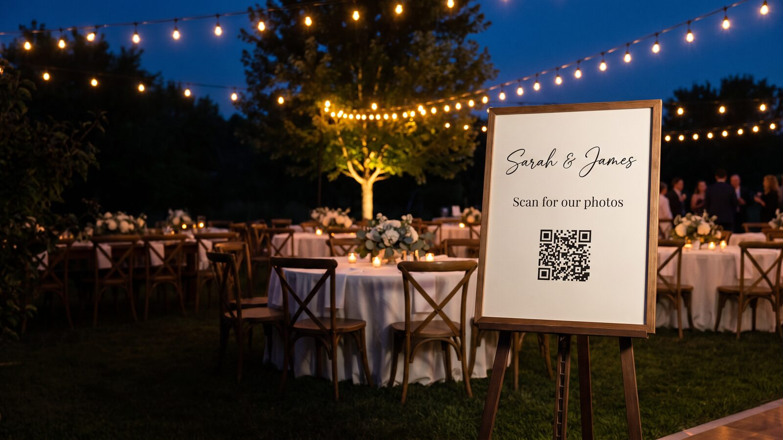 An elegant "Scan for our photos" easel sign at a wedding reception
